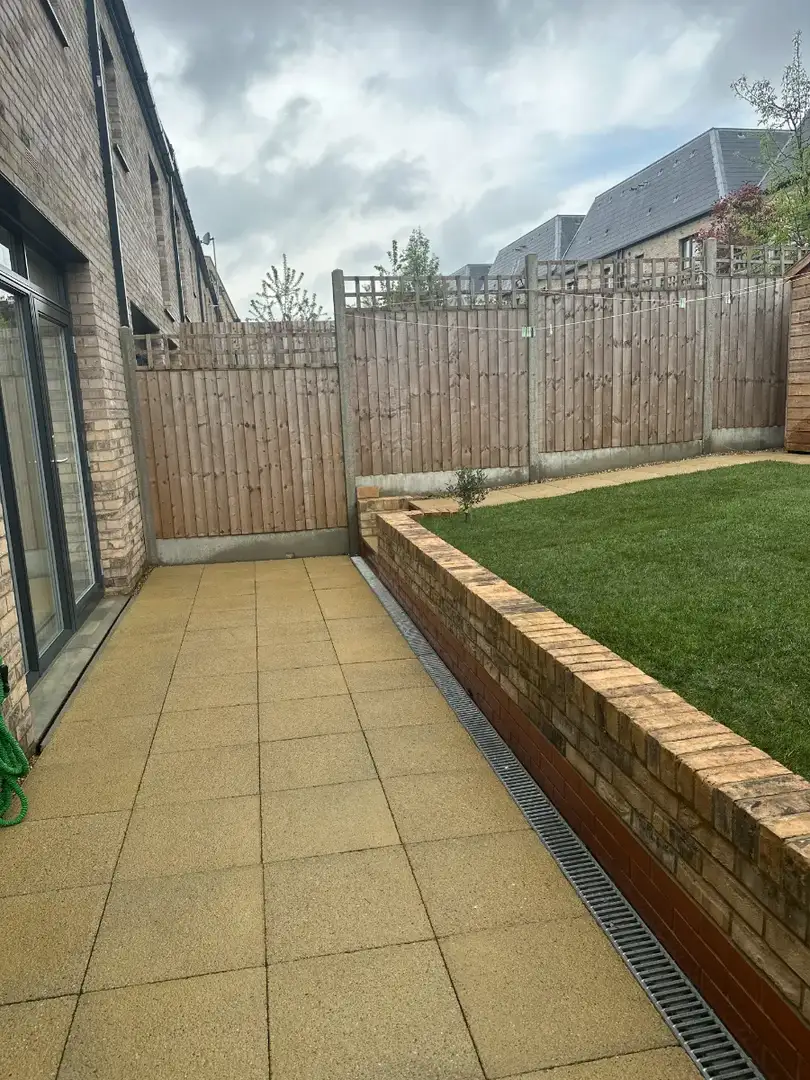 Paved path beside a fence and raised bed
